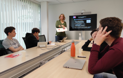 Group of students in second year around a table listening to the teacher-researcher Elisa Fromont during a presentation on artificial intelligence (AI)